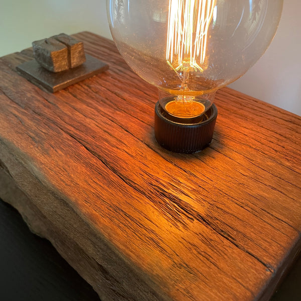 Wood table lamp upcycled from wharf timber with original bolt and edison bulb, close up of top section and bolt, by shades at grays.