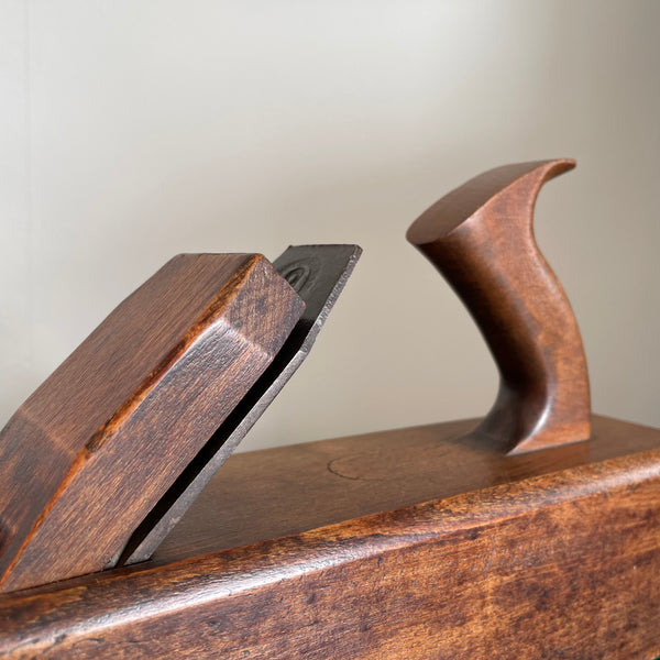 Wooden table lamp upcycled from authentic carpenter's plane, close up of half tote handle and blade.