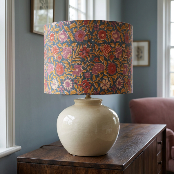 Floral drum lampshade on a large ivory ceramic base in a blue-grey interior