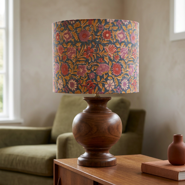 Floral drum lampshade on a large timber base in a warm living room