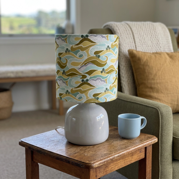 Hills and Trees lamp beside an olive armchair in a country holiday home