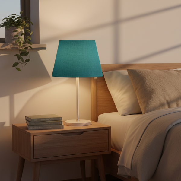 Teal linen lampshade on nightstand in cozy bedroom corner