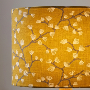Close up of lit drum lampshade in Spring Buds Sunflower fabric.