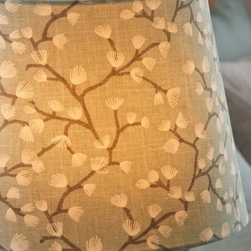 Close up, lit tapered lampshade in Spring Buds Seafoam fabric 