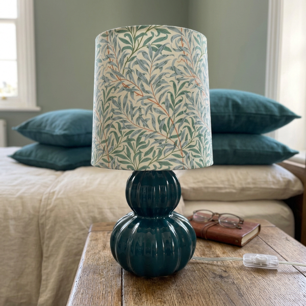 Willow Boughs teal table lamp styled beside a cream linen bed