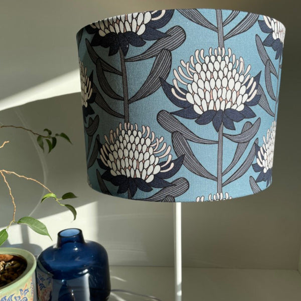 Blue and white waratahs fabric on medium drum light shade and white stand.