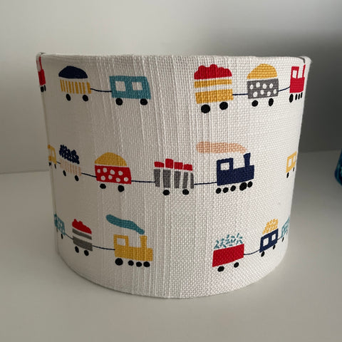 Childrens light shade with trains and multi-coloured wagons on textured white background