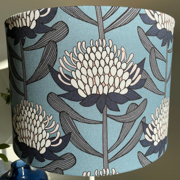 Close up of blue and white waratahs fabric on medium drum light shade.