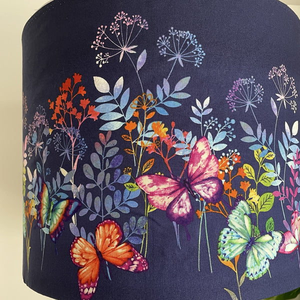 Close up of butterflies and foliage on dark indigo background on large drum hand crafted lamp shade.