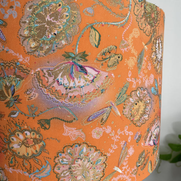 Close up of delicate dragonflies and blossom on tangerine background, handcrafted lightshade, unlit