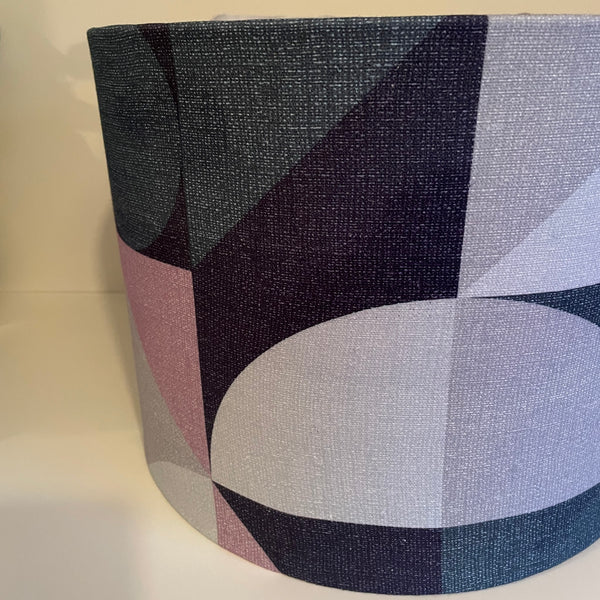 Close up of geometric pink-grey fabric on large drum fabric light shade, made by Shades at Grays.