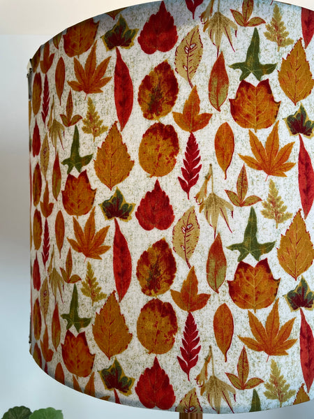 Close up of large hand made light shade with autumn leaves fabric, lit.