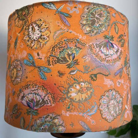 Delicate dragonflies and blossom on tangerine background, handcrafted lightshade, lit