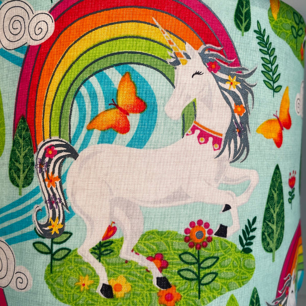 Fabric sample with close up of white unicorn, rainbow and orange butterflies