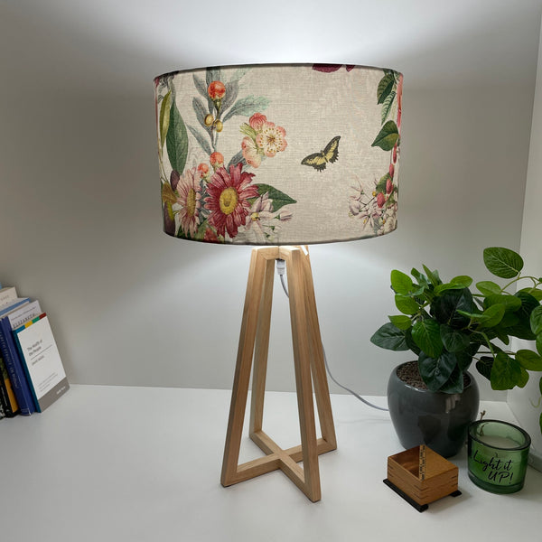 Handcrafted fabric lampshade on modern natural wood base.
