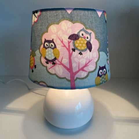 Handcrafted small tapered childrens lampshade with owl pattern, lit.