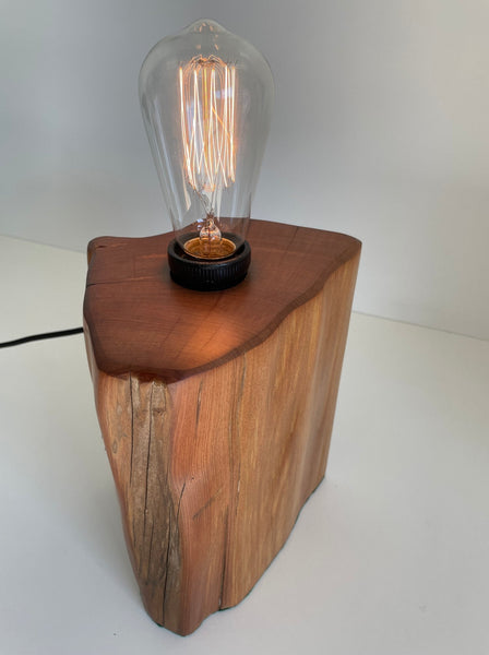 Honey coloured wooden table lamp, handcrafted from old totara post with edison light bulb