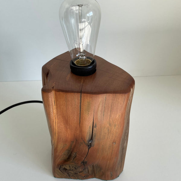 Honey coloured wooden table lamp, with original staple from old totara post, polished with natural beeswax