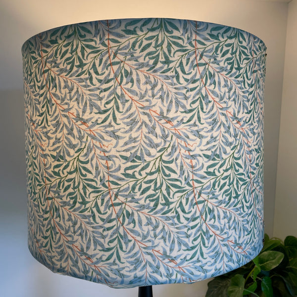 Large drum hand crafted lamp shade in William Morris Willow and Boughs Cream fabric, lit.