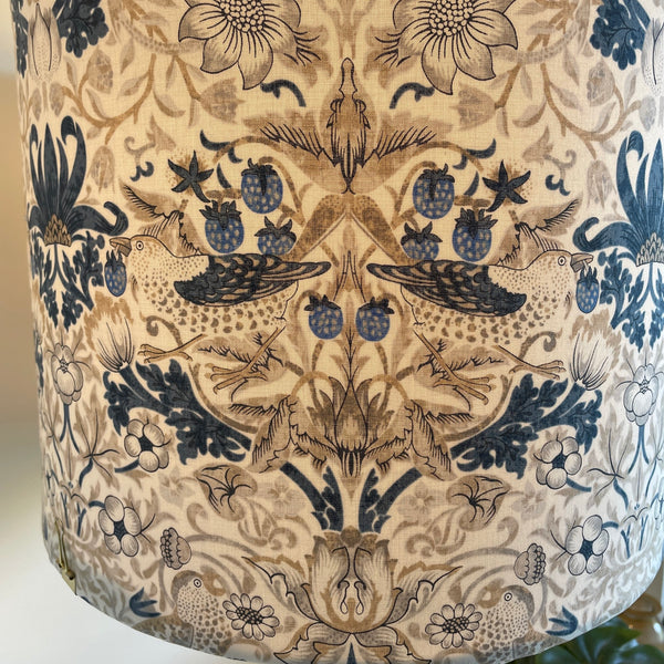 Large drum handcrafted lamp shade with William Morris fabric, lit, close up..
