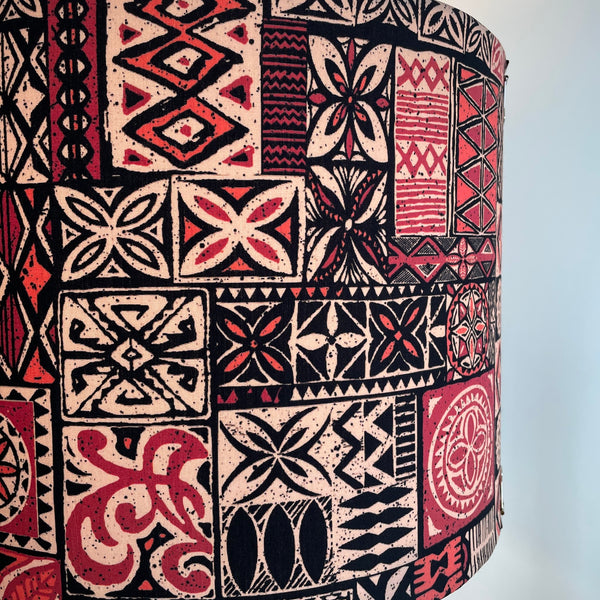 Close up of Large drum fabric lamp shade with Pacific style tapa design fabric., lit.