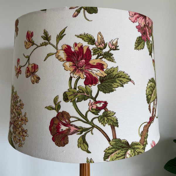 Large tapered fabric lamp shade with flowers on a white background, unlit.