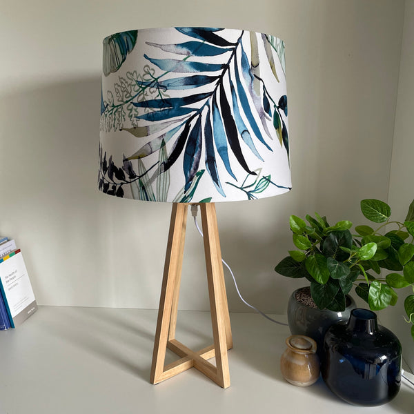 Natural wood table lamp with handcrafted fabric lampshade, unlit.