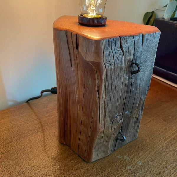 Front and left side of old totara post crafted wooden table lamp.