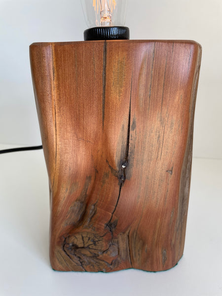 Polished smooth front of wooden table lamp with original stape and attractive knot.