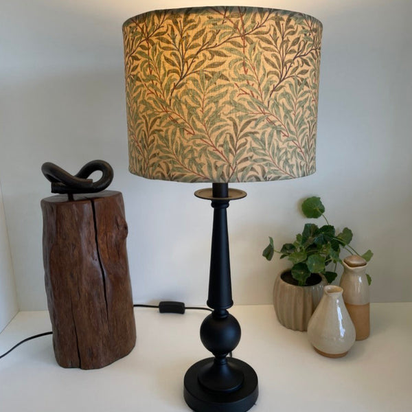 Shades at Grays Bespoke large drum lampshade with Morris & Co Willow Boughs - Sage Green. Lit, on black stand.