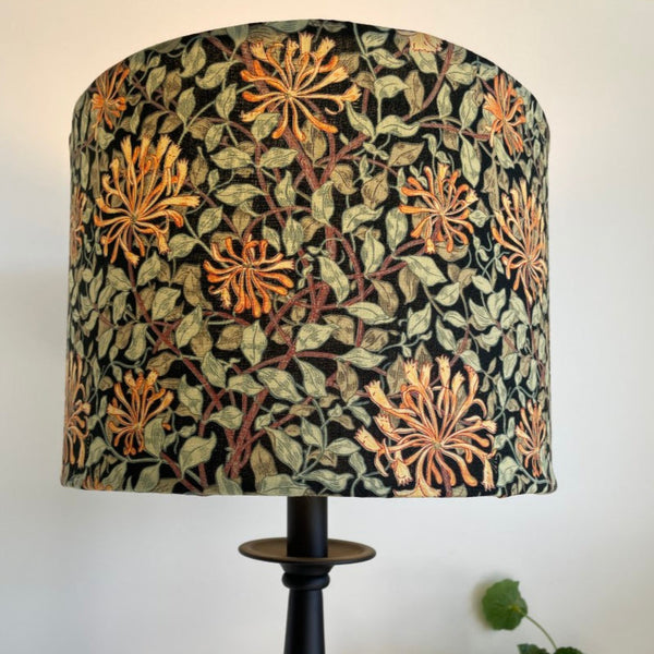 Shades at Grays bespoke large fabric lampshade from Morris & Co honeysuckle black fabric. Lit on black stand.
