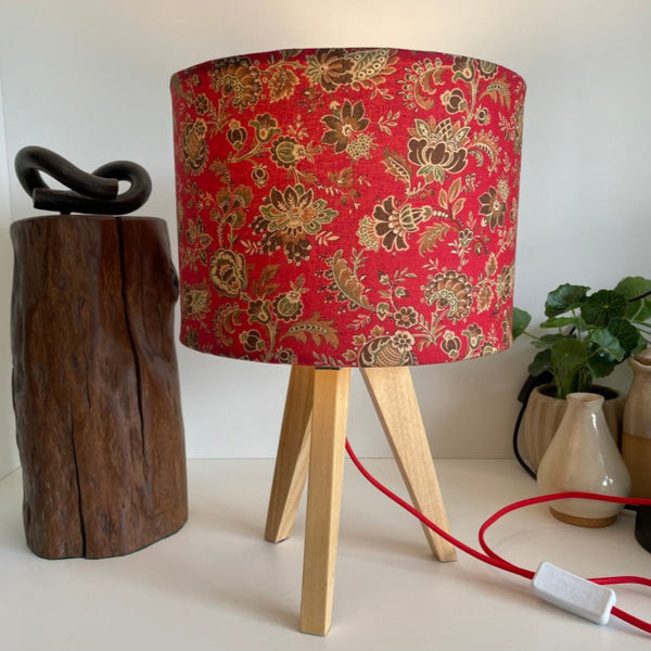 Shades at Grays bespoke medium drum fabric lampshade, French General Lavigne Rouge fabric. Lit on natural wood tripod table lamp.