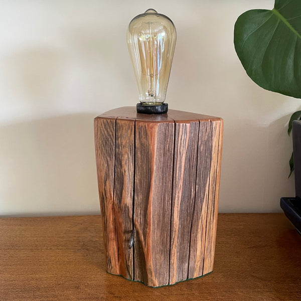 Timber table lamp, polished totara grain with original iron staples and edison light bulb.