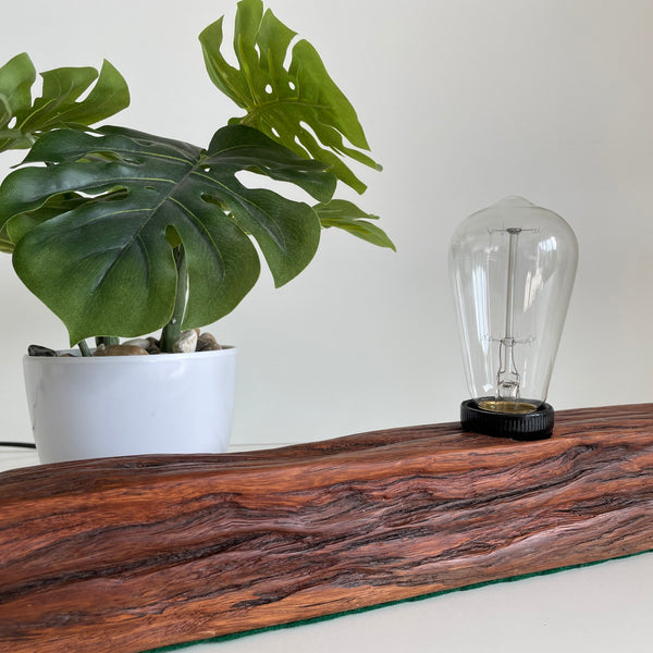 Wooden table lamp handcrafted from old telegraph post with edison bulb, unlit.